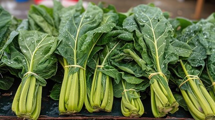 Obraz premium Fresh collard greens bundled and ready for sale or distribution with water droplets on their leaves