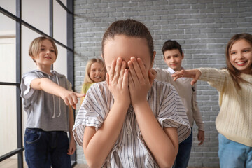 Bullied little girl crying at school, closeup