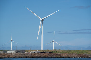 秋の青空の下、自然エネルギーで発電する風力発電（秋田港）