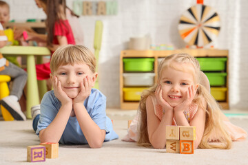 Little children lying on floor in kindergarten