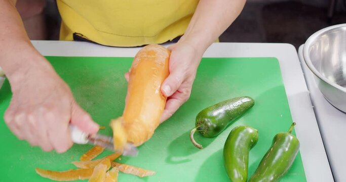 Cook peels carrots and other vegetables.
