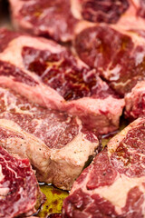 Juicy Black Angus steaks marinated with spices. Close-up shot. vertical frame