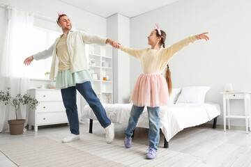 Fototapeta premium Father and his daughter in princess costumes playing in bedroom