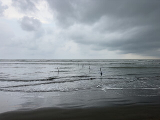 Fototapeta premium Traditional fishing nets on deserted beach with storm in background, Cox's Bazaar, Bangladesh
