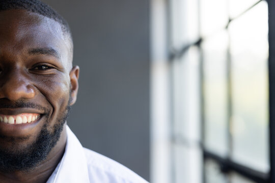Young African American male with short black hair and beard smiling