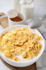 Breakfast cereal. Tasty corn flakes with milk in bowl on table