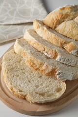 Freshly baked cut sourdough bread on white wooden table
