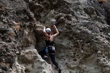 Sporty woman climbing on rock wall
