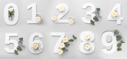 Numbers and beautiful flowers on light grey background, top view. Banner design