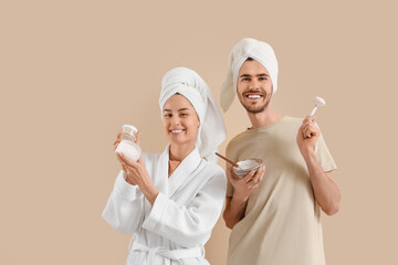 Young loving couple after shower with skincare products on beige background