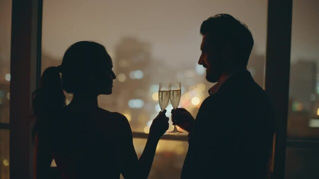 Romantic spouses silhouettes celebrating anniversary night city window closeup