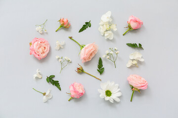 Beautiful composition with flowers and green leaves on grey background