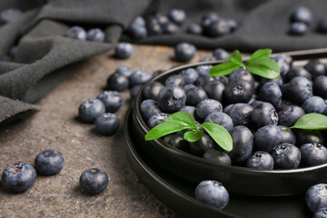 Plate with sweet fresh blueberries on grey background