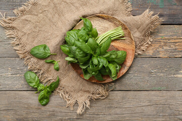 Board with fresh green basil leaves on wooden background