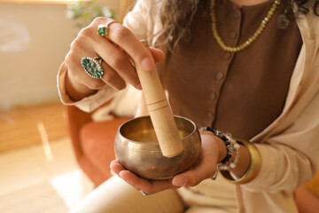 Young witch with Tibetan singing bowl at home, closeup