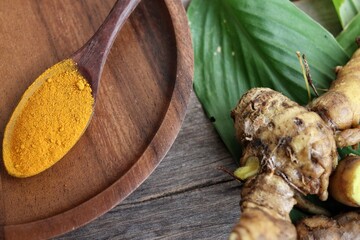 Turmeric root powder on wood background