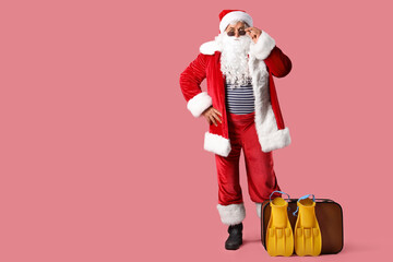 Santa Claus with flippers and bag on pink background. Christmas in July