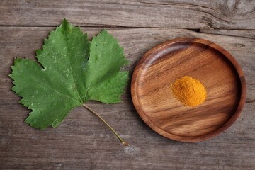 Turmeric root powder on wood background