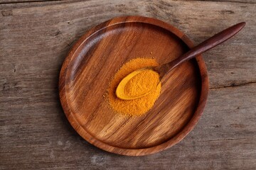 Turmeric root powder on wood background