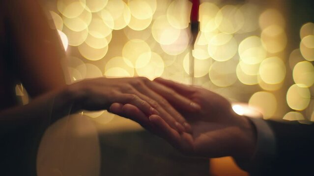 Evening couple touching hands at blurred background closeup. Happy woman talking