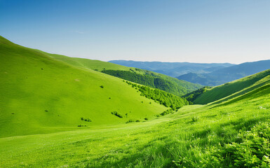 Obraz premium Scenic Green Hills And Valleys Under Clear Blue Sky