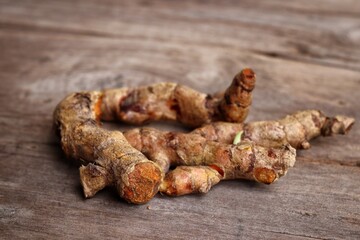 Turmeric root on wood background