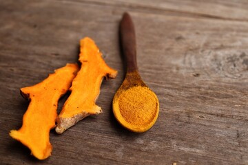 Turmeric root powder on wood background