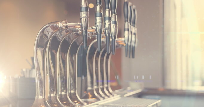 Sunlight highlighting beer taps at bar, showcasing their sleek design