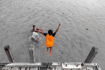 person jumping from boat ramp