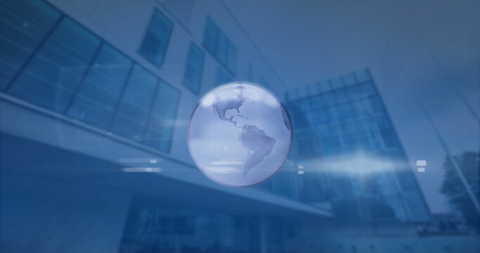 Image of spinning globe and light spot against low angle view of tall building