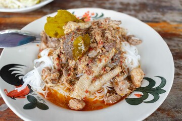 rice noodle chicken leg curry on white plate