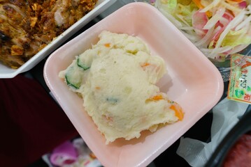 Potato salad in a pink foam plate