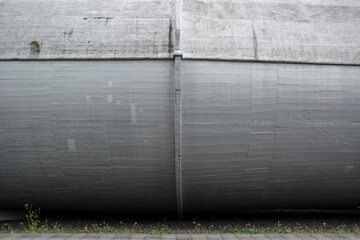 A detailed close-up of a large industrial concrete structure, showcasing its robust and weathered...