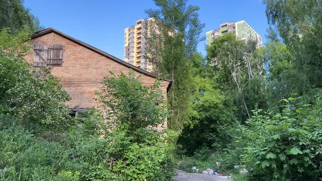 Urban Encroachment: The Vanishing Suburban Idyll as High-Rise Modernity Engulfs an Abandoned Single-Family Home. Wide angle view
