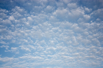 Floating clouds in the sky on a clear day. White clouds on the blue sky in summer. Lots of fluffy...