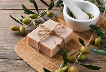 A bar of handmade olive oil soap rests on a wooden table