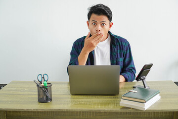 young asian freelancer in workplace doing surprise gesture, isolated on white background