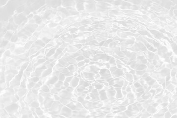 White water with ripples on the surface. Defocus blurred transparent white colored clear calm water surface texture with splashes and bubbles. Water waves with shining pattern texture background.