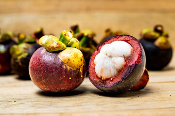 Mangosteen fruit isolated on wooden background. Mangosteen is known as a fruit that has very high...