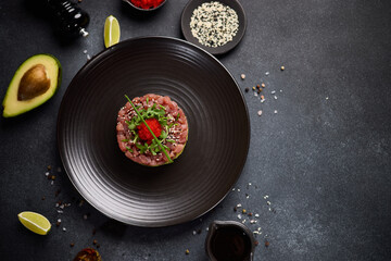 Tuna and avocado tartare on a dark ceramic plate