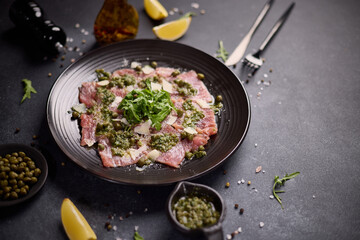 tuna carpaccio - slices of fresh raw tuna fillet on black ceramic plate