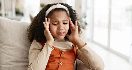 Little girl, headache and sofa with stress in anxiety, depression or loneliness at home. Young...