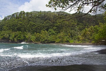 Waves crash on the soft, black, volcanic sand of the island of Tahiti © Andrew Webb Curtis