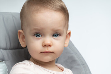 Close-up of a toddler baby gazing at the camera with calm face