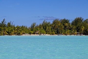 Pastel-colored waters lap up on the white sand beaches of Bora Bora