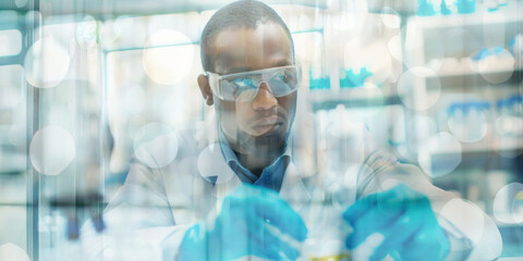 A diligent African American scientist wearing safety goggles and gloves, carefully conducting an experiment in a laboratory.