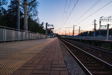 A beautiful railway station in the rays of a colorful sunset