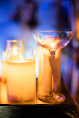 Cocktail glass and candle on a dark background