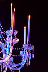 Noble and luxurious crystal chandelier with candles. Closeup crystal pendants of chandelier light,...