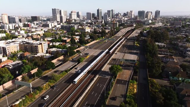 Air over freeway and houses towards skyscrapers in downtown Oakland, California